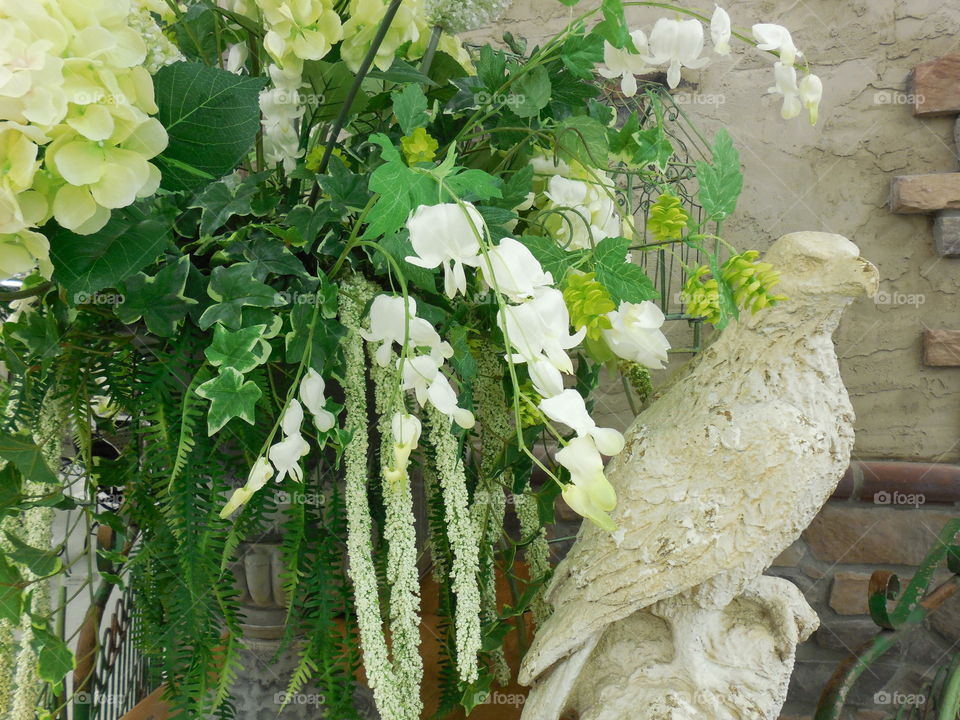 Green and white floral decor with stone eagle