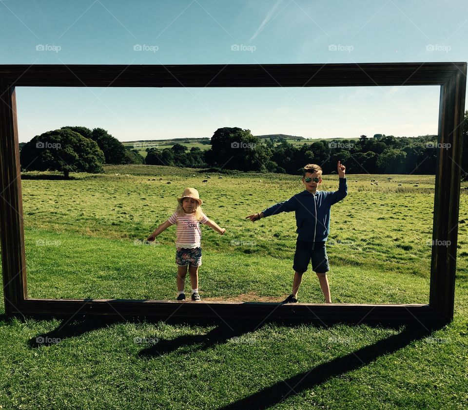Boy and girl posing in front of big wooden frame