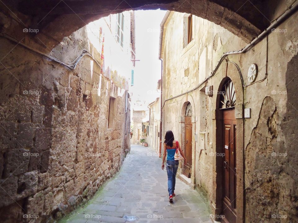 Woman is walking in an alley . ITALIAN alley