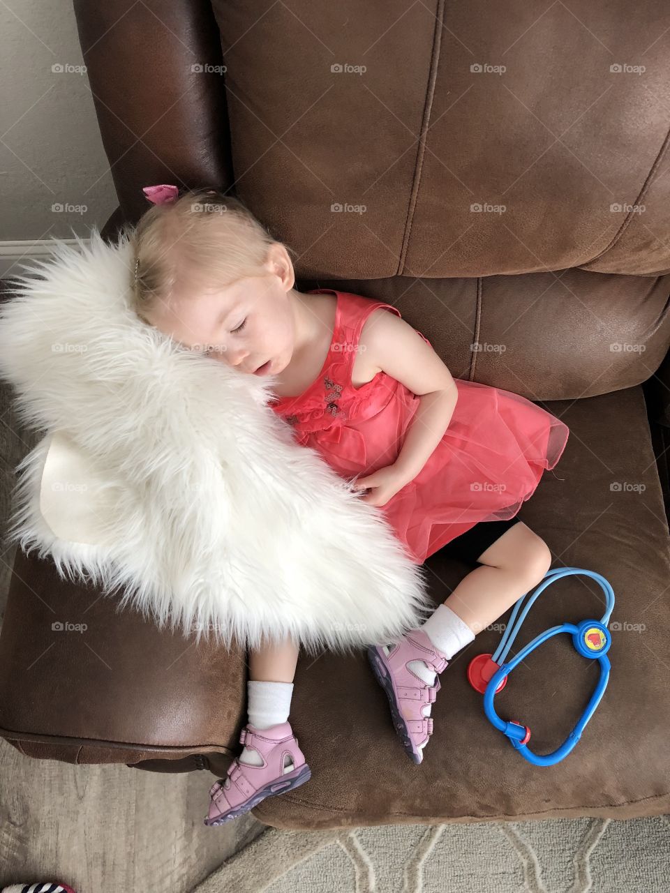 Two year old girl sleeping on sofa 