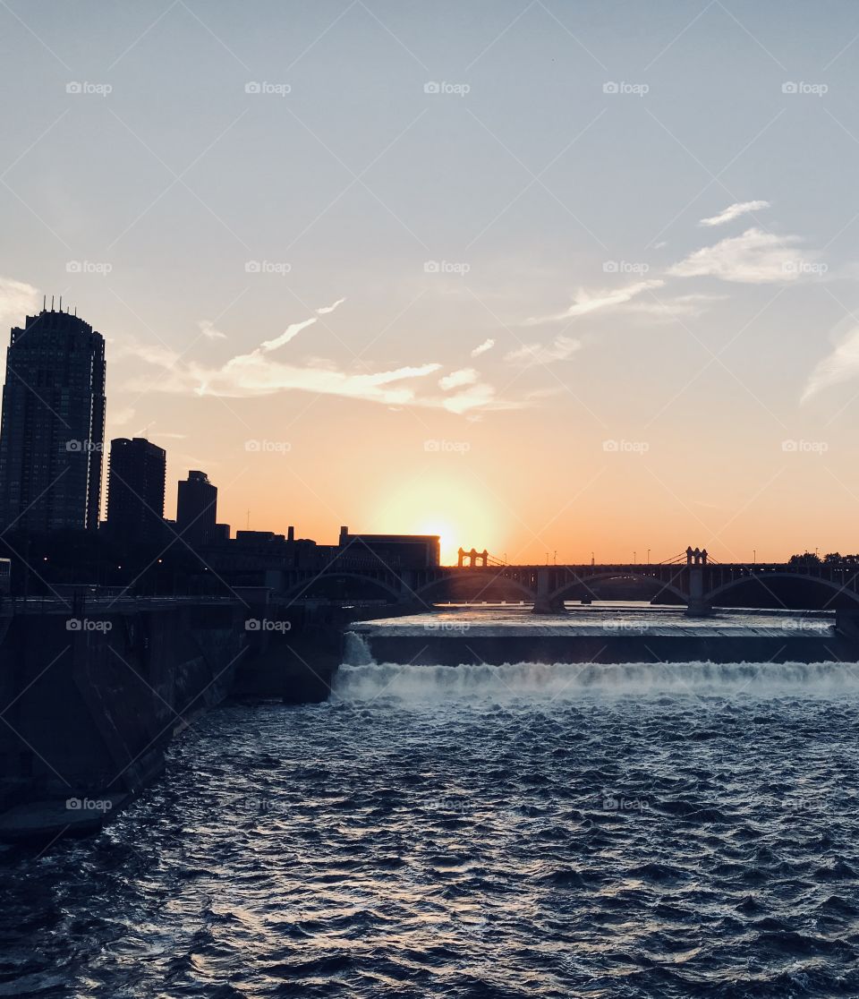 Sunset over the Mississippi River overlooking it from Stone Arch Bridge. Wondrous waterfall and scene of beauty.  