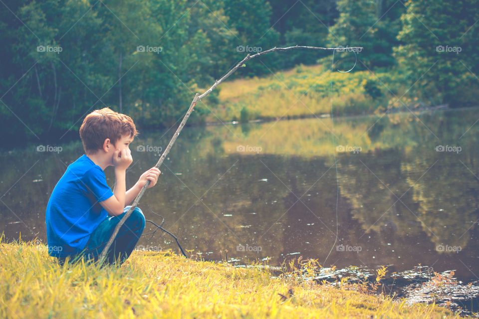 Young Boy Fishing by a Pond with Stick Pole 3