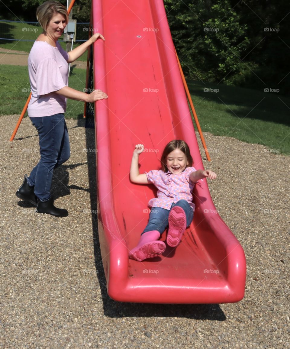 Playing on the playground, going down the sliding board 