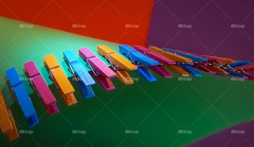 Coloured wooden pegs against a coloured geometric background 