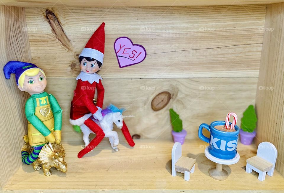 Elves go on a date, elves riding unicorns and stegosaurus dinosaurs, drinking peppermint hot cocoa, elf on the shelf funny scenes, playing with kids around Christmas time 