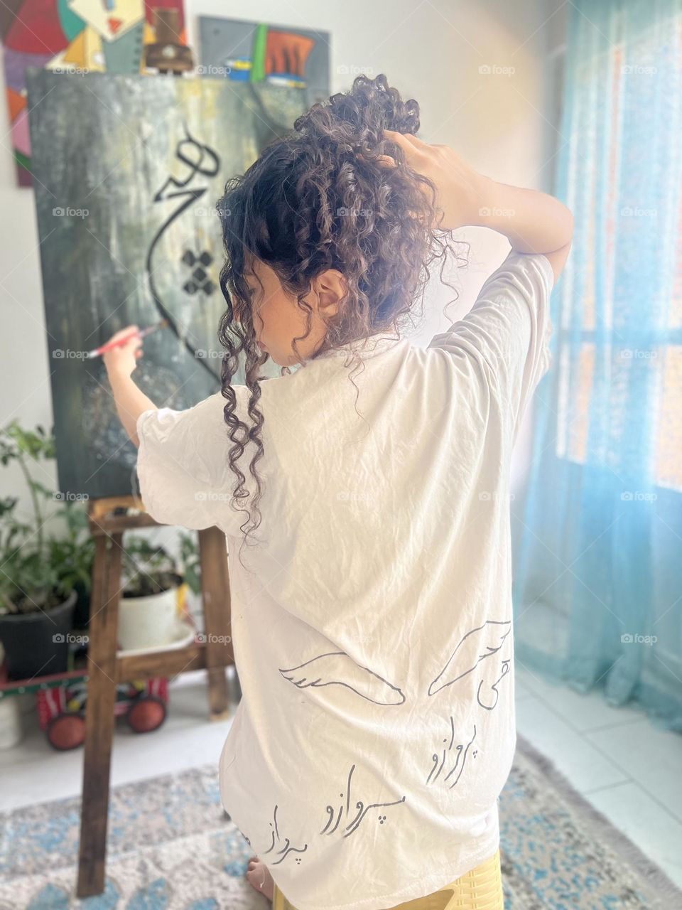 Curly-haired girl and painting canvas