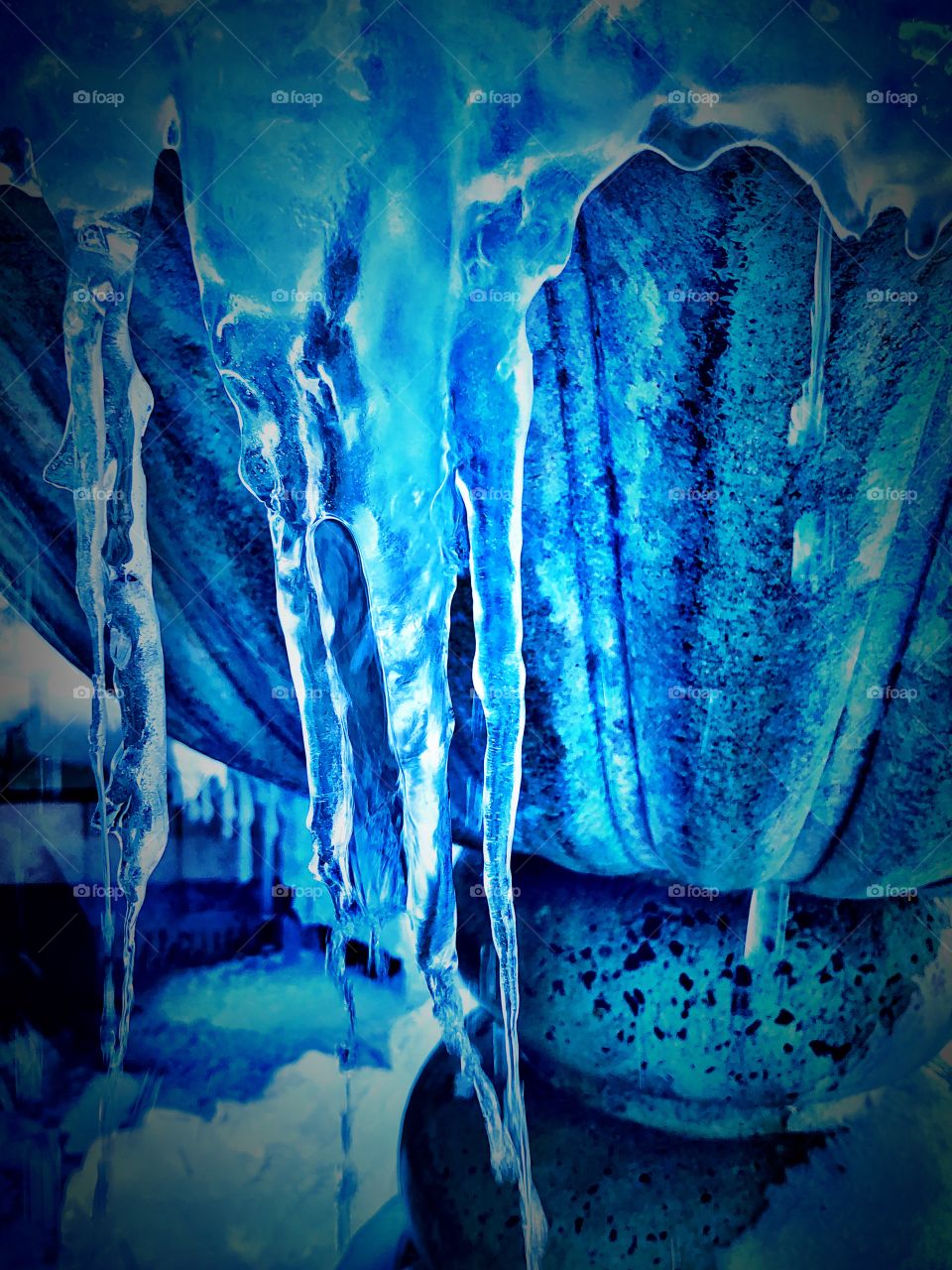 Blue dripping frozen fountain in the winter 