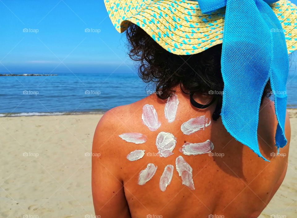 girl sunbathes and protects herself with sunscreen