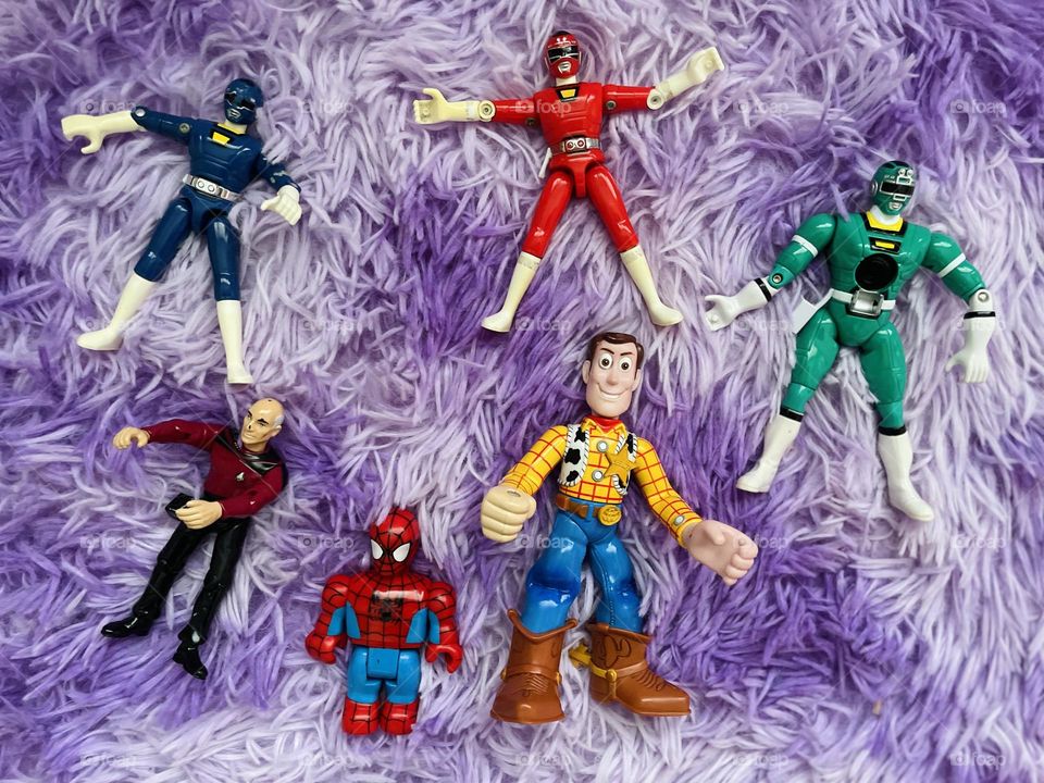 Action figures from different genres, fun plastic action figures, acting silly with action figures, posing action figures on a playroom carpet, children’s toys 