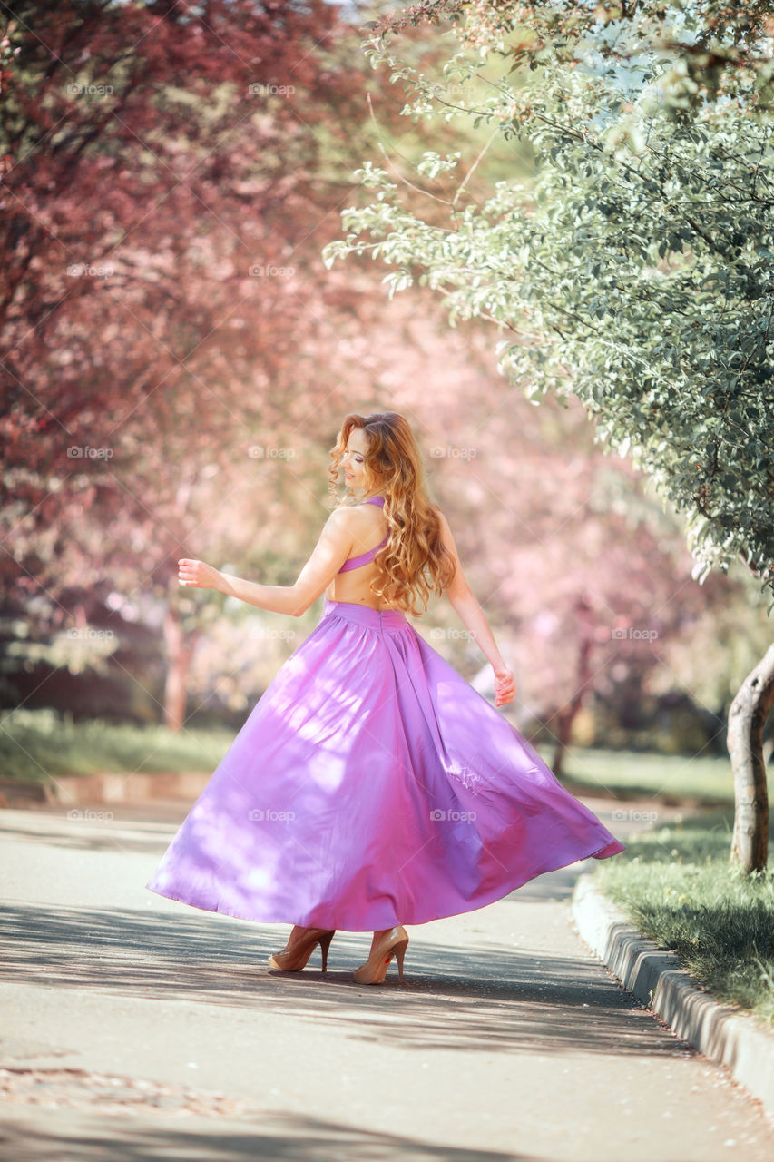 Beautiful young woman in a blossom park 