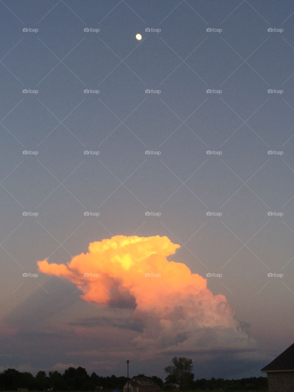 Sunset thunderhead with a full moon.