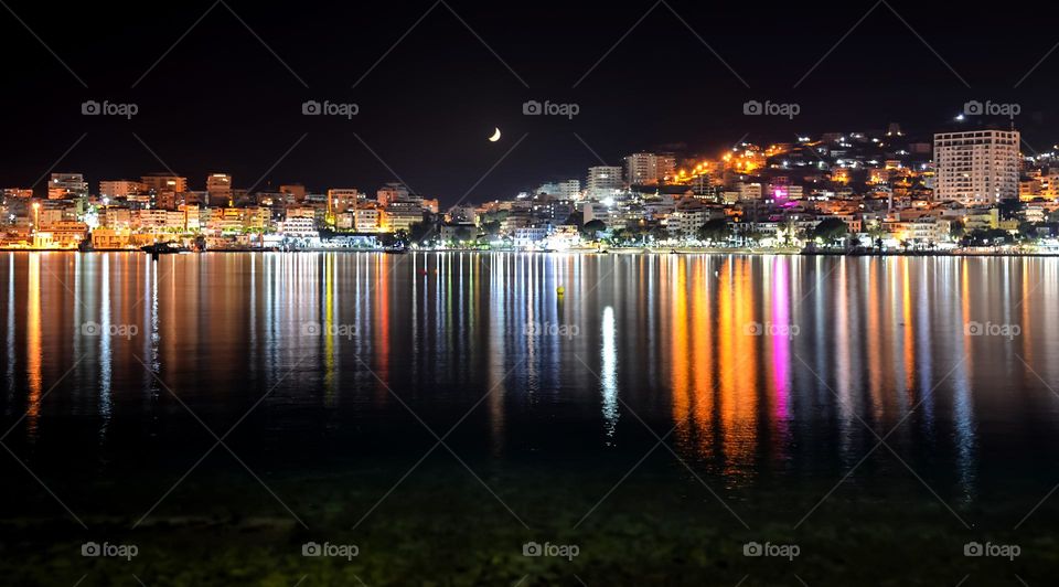 City Saranda Lights Reflected on Body of Water During Night