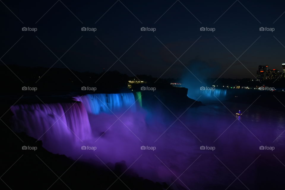 Niagara Falls at night with colored lights shining on the falls