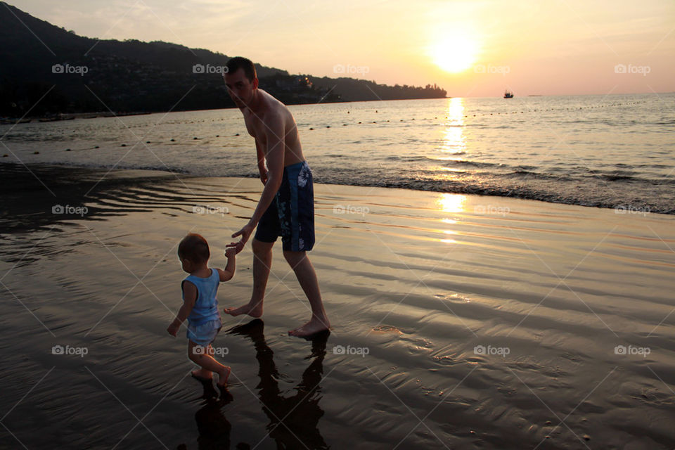 father and son walking on the beach 