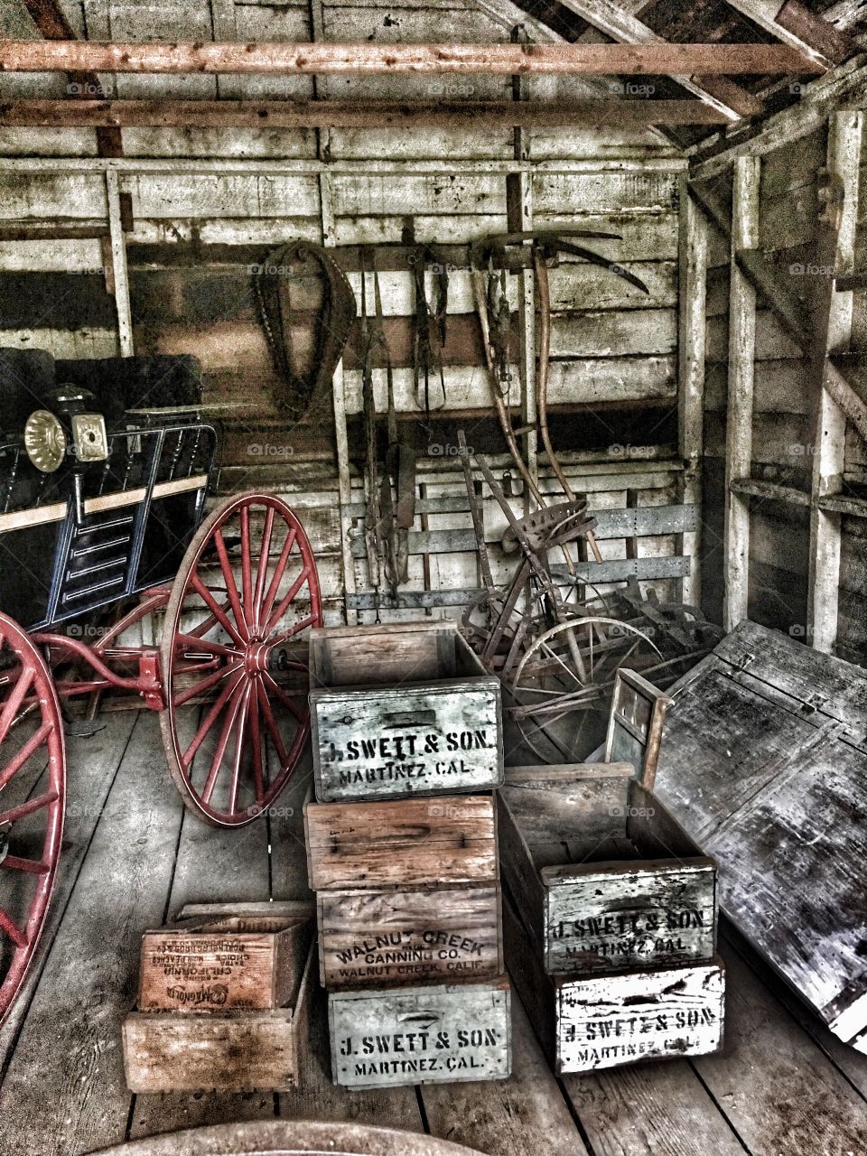 Old carriage house on John Muir historic site with old carriage, wooden boxes, bicycles and tools. 