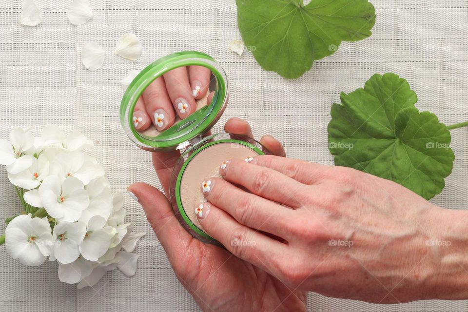 Woman's hands are holding makeup powder