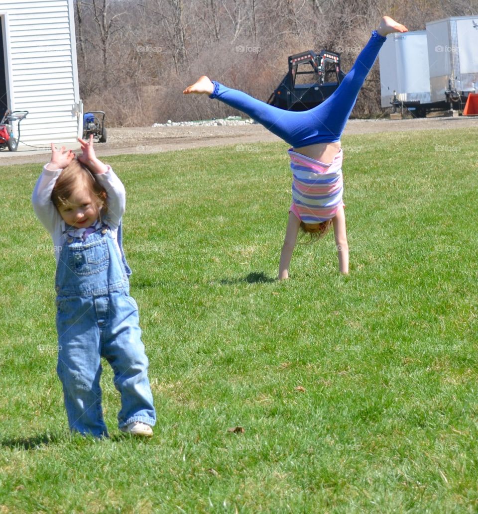 Spring cartwheels. Girls having fun in the spring sun