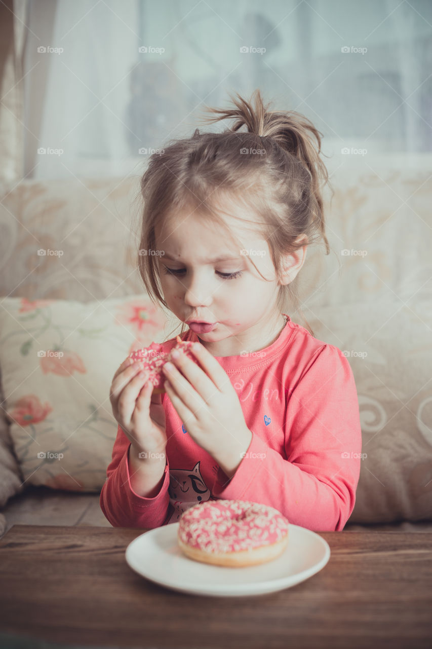 Little girl eating donuts 