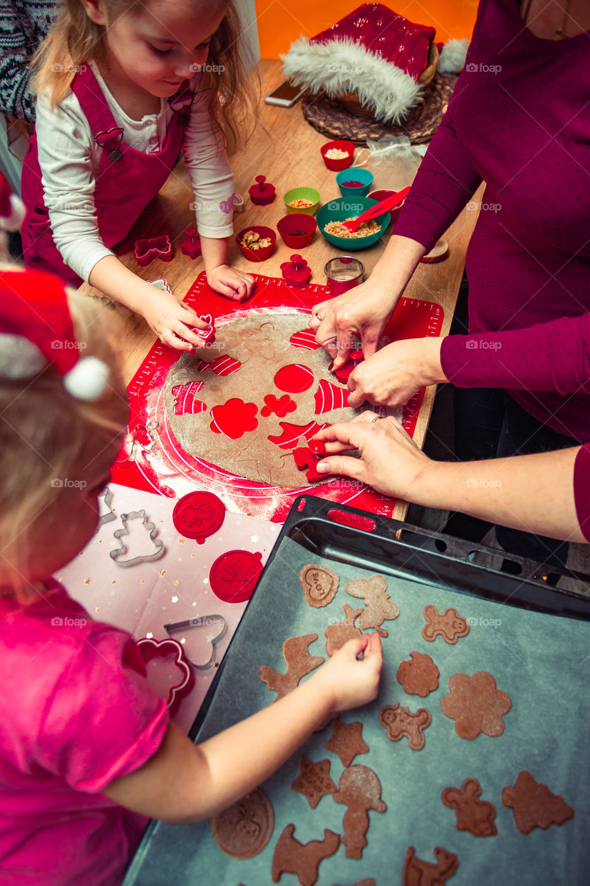 Baking Christmas cookies. Christmas gingerbread cookies in many shapes decorated with colorful frosting, sprinkle, icing, chocolate coating, toppers, put on table. Baking traditional cookies. Family celebrating Christmas. Baking at home