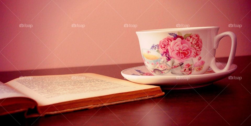 Opened book and coffee cup on table