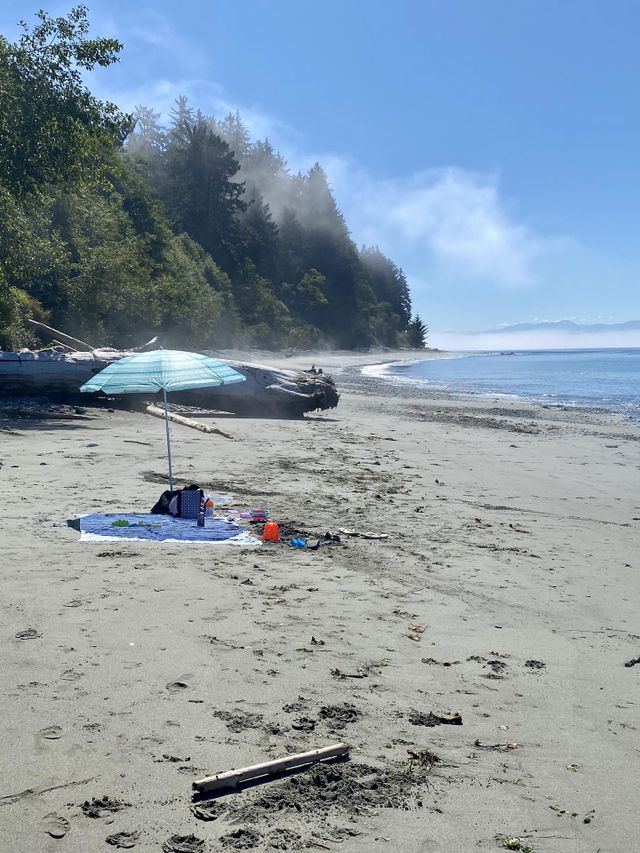An early morning beach day in the Pacific Northwest Canada. A umbrella, blanket, and beach accesories