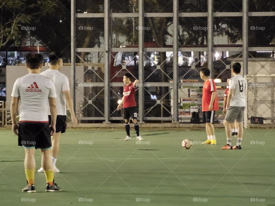 Men playing soccer after the rain at Hong Kong Victoria Park