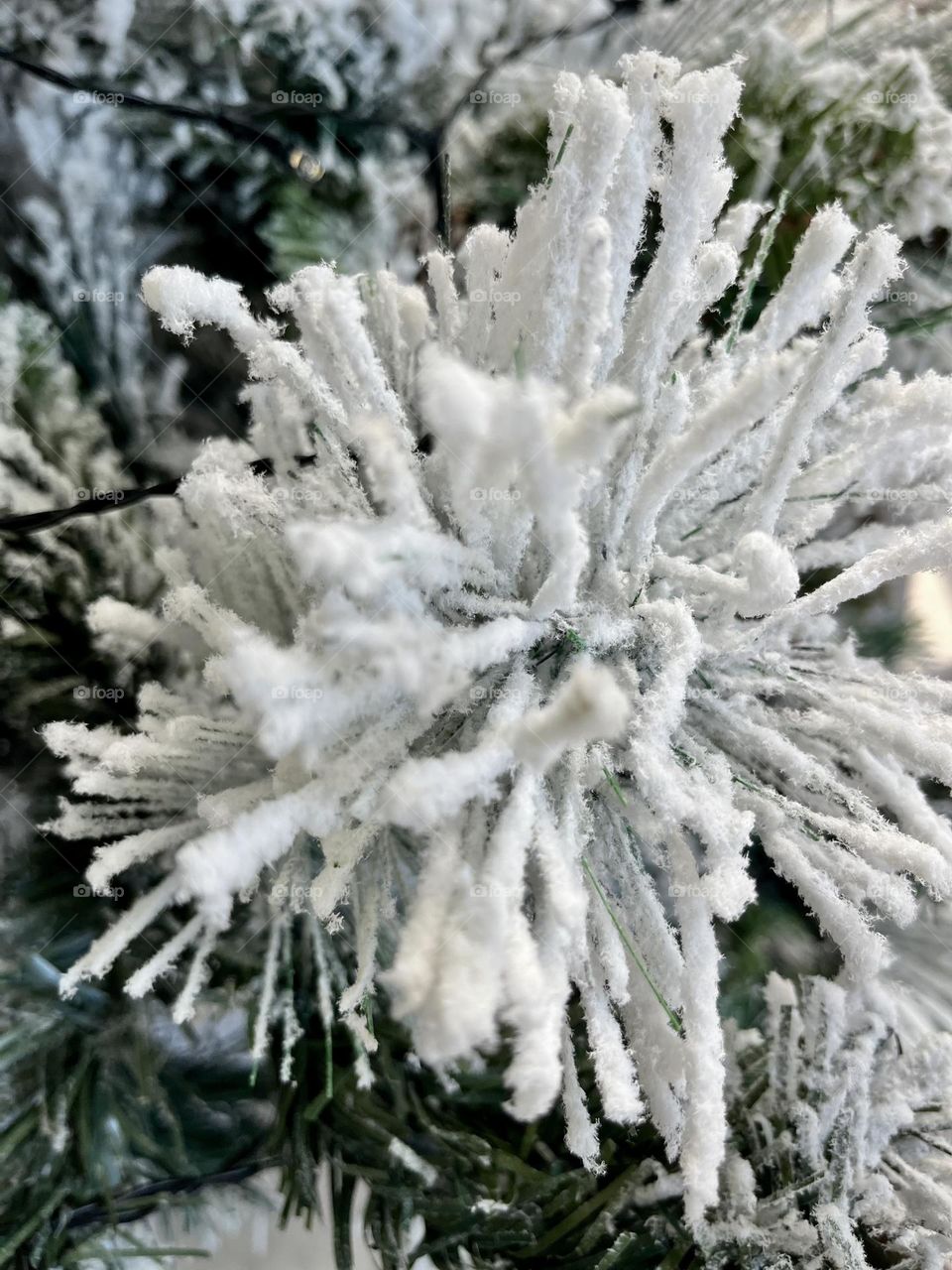 Close-up of a snowy artificial Christmas tree branch