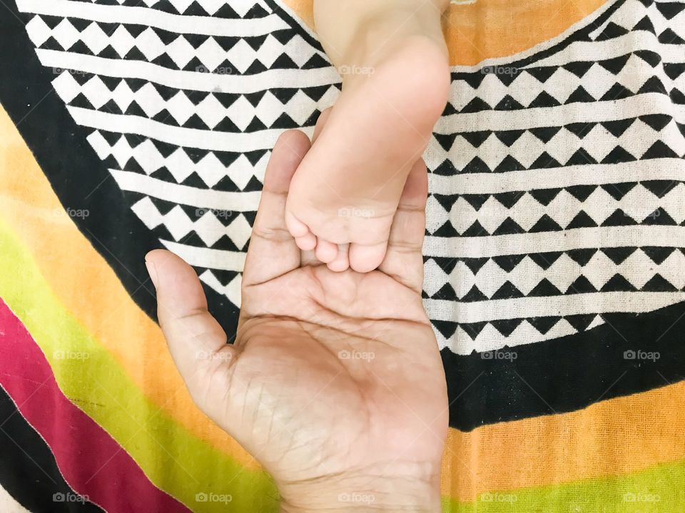 Child's feet on the palm of the father