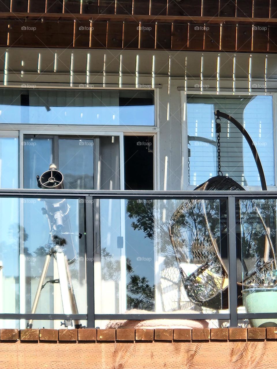 a deck chair and telescope on an apartment deck  in Oregon as a place to rest and soak up sun during a warm day or cool off and watch the stars at night