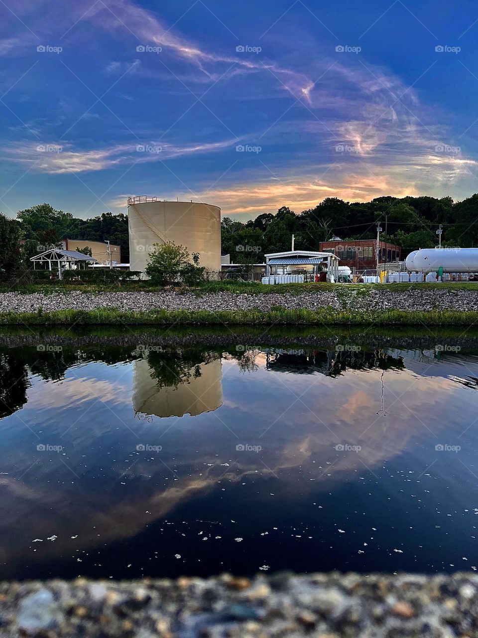 This serene reflection image of the Blackstone River was captured with my iPhone during the Golden Hour, and features placid water and golden sunlight setting on the horizon. (Woonsocket, Rhode Island)
