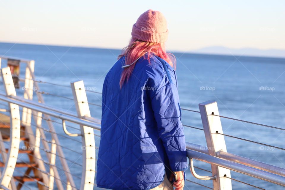 Woman with blue coat watching afar 