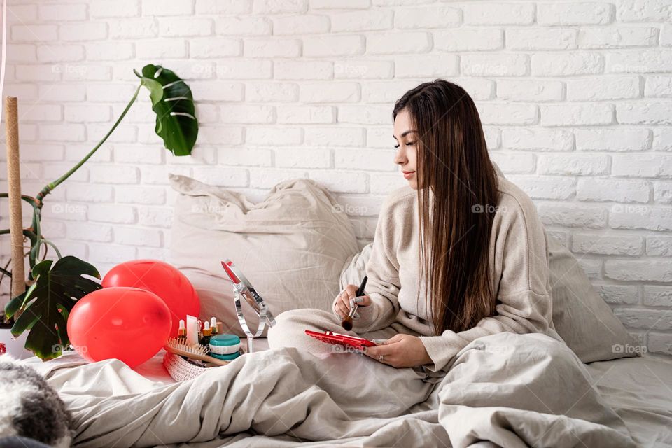 woman using cosmetics at home