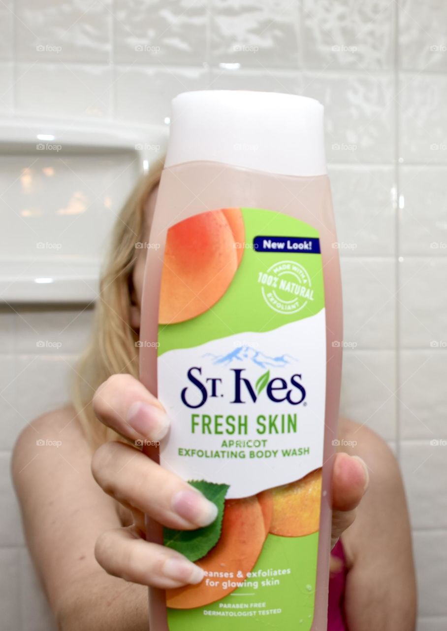 St Ives apricot exfoliating body wash closeup held by a woman 