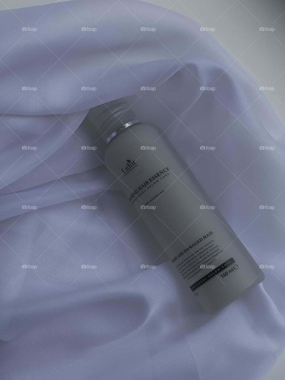 
In the photo, a sleek, minimalist hair product bottle is featured against a clean background. The label on the bottle is simple yet elegant, showcasing the name of the product and its key ingredients.