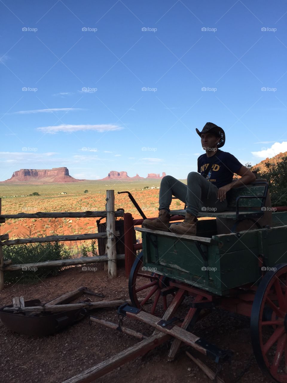 Young man sitting on old weathered cart