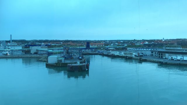 The port of Hirtshals in Denmark. The water is almost not moving because of the calm weather. You see the port towards the city of Hirtshals. The blue “thing” in the picture is the car way for the Color Line ships. Taken in Denmark an April night.