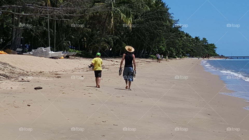 father & son walking along a beach