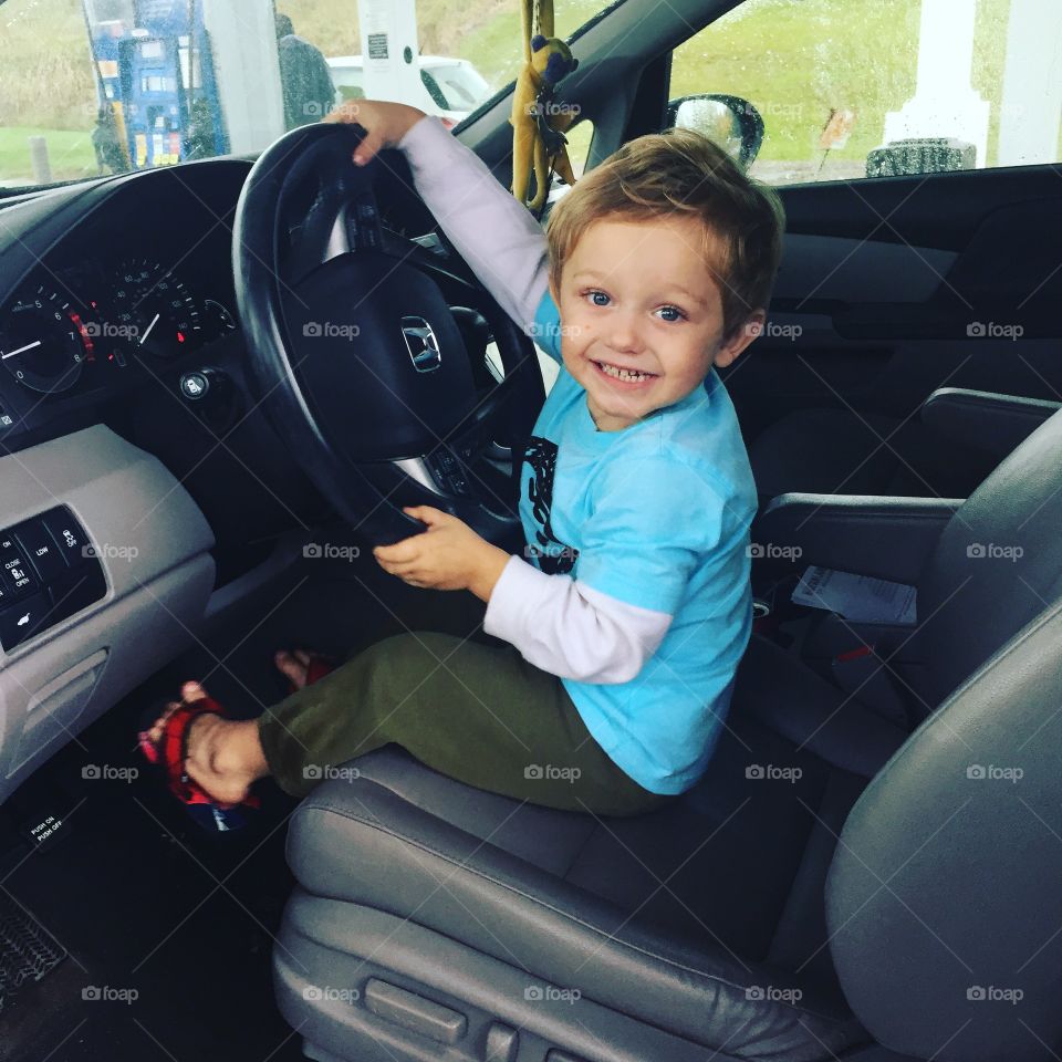 Boy holding car steering