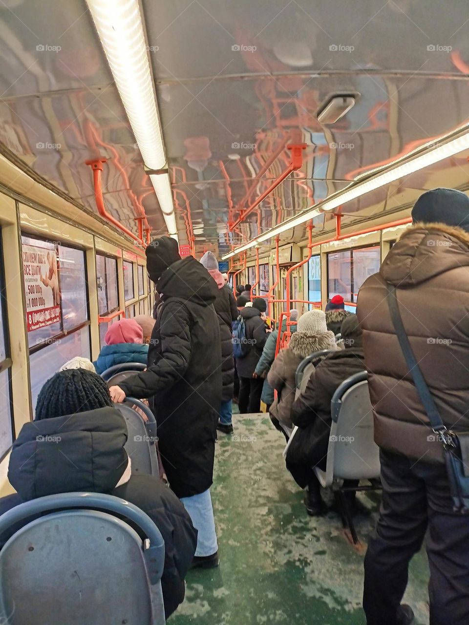 public transport, tram, many people, passengers, warmly dressed people ride in the tram, windows, clothes, winter, crowd