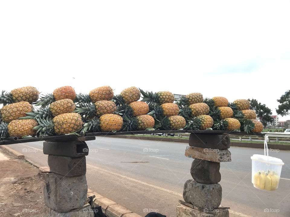 People selling pineapples .This is a busy superhighway.