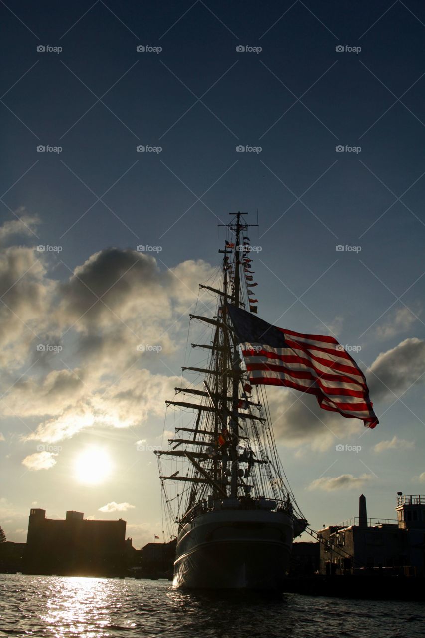 Large wooden sailboat with American flag. 