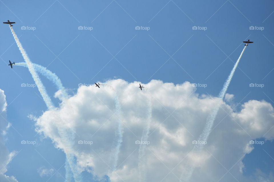 White fluffy clouds and blue sky with jets going through the clouds