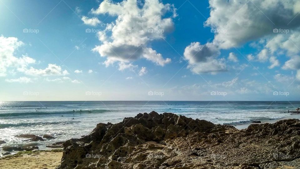 Coral rocks on the beach, under a cloudy sky in landscape angle view