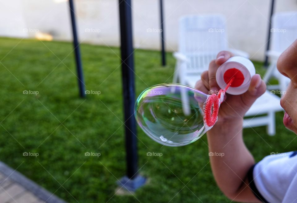 child makes soap bubbles