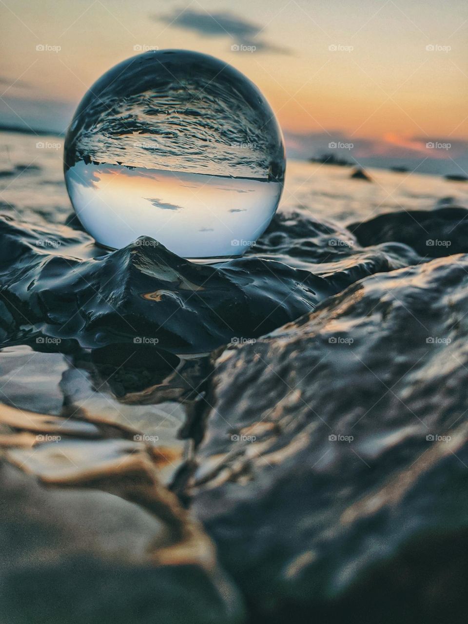 Top view of lensball,  crystal ball at the Adriatic seaside against sunset sky close up.