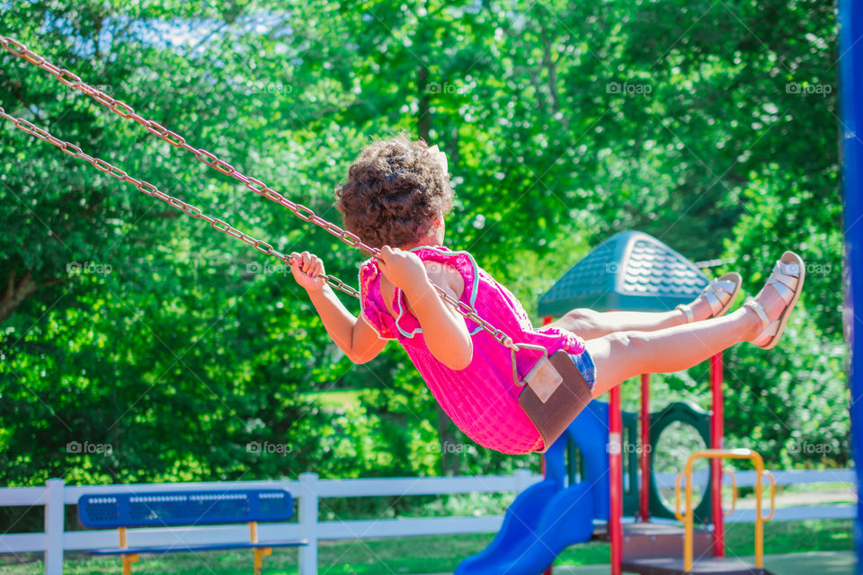 Young Girl Swinging at a Playground 