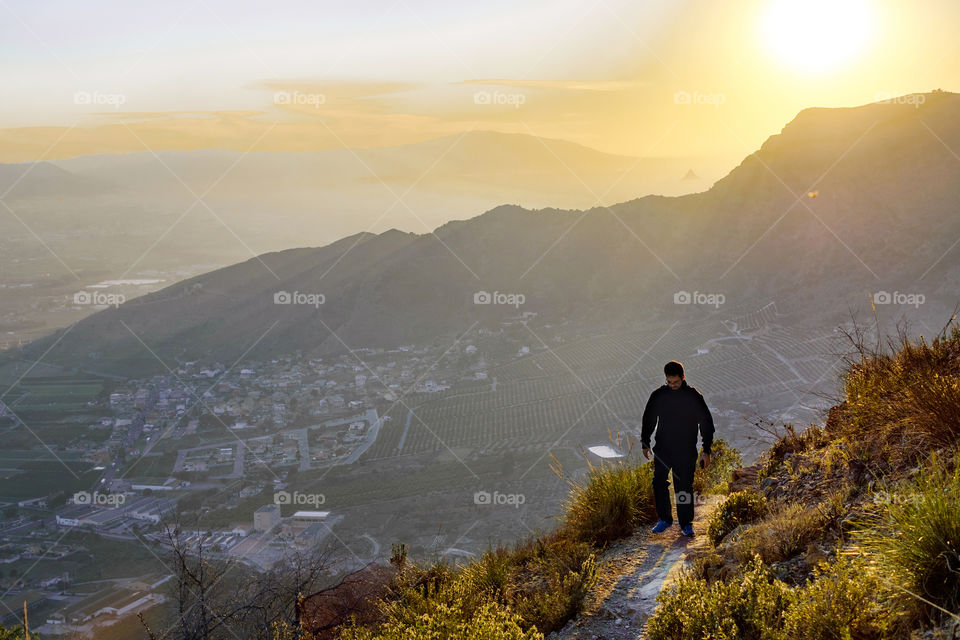 Sportsman hiking over cliff at mountain top in Spain, 2019.