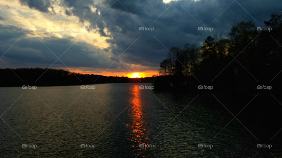 dark clouds during sunset on lake.