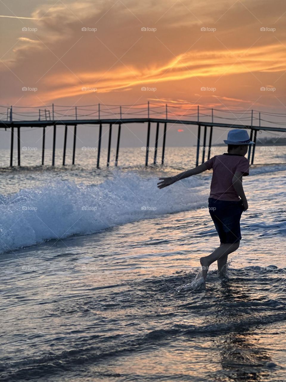 Boy resting run on the pier by the sea