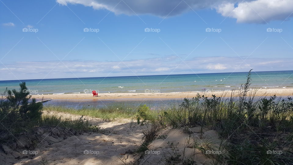 lone Adirondack chair on the beach